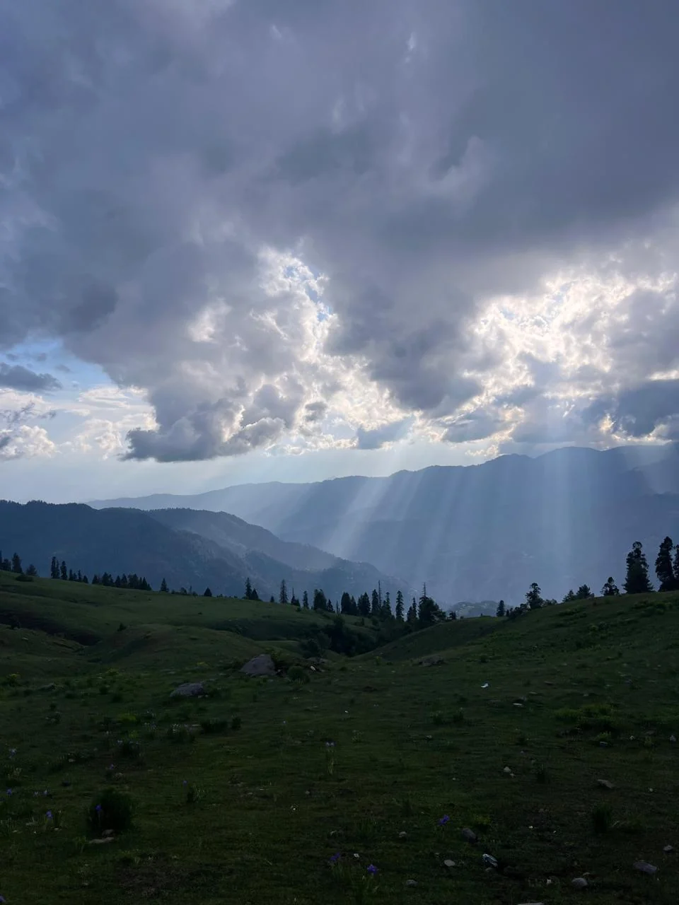 Sunlight breaking through clouds over the mountains